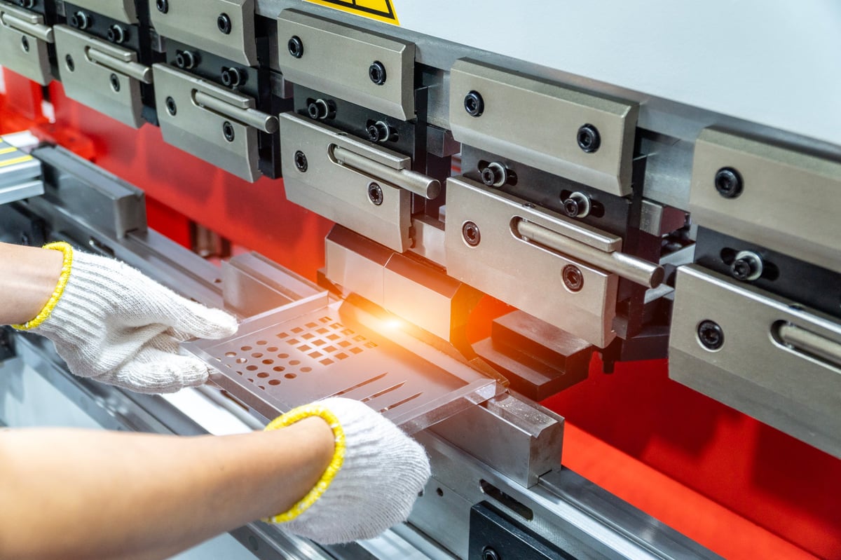The technician operator working with sheet metal on CNC hydraulic press brake