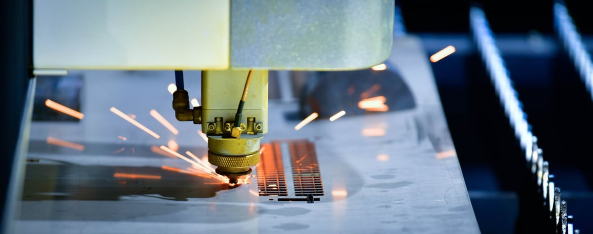 Industrial CNC laser cutter processing steel plate in metalworking factory